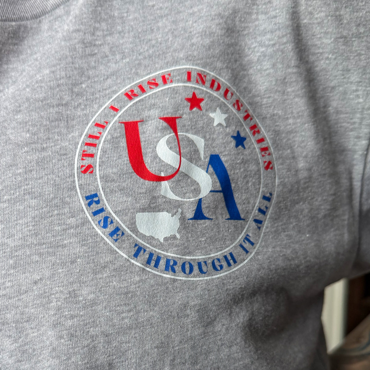 Gray t-shirt with a circular logo featuring 'USA' and text on a gray background